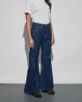 Jean de denim azul oscuro con diseño acampanado y costuras decorativas a contratono en las piernas.