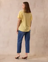 Remera blanca de lino con mangas cortas y fruncido en los hombros.