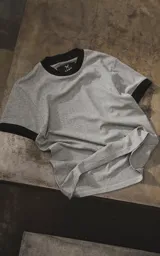 Remera gris melange de manga corta con cuello redondo y ribetes negros en cuello y puños.