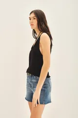 Top sin mangas de tejido de punto compacto con escote en U pronunciado. Presenta una textura sedosa y brillante, con un diseño ajustado al cuerpo.