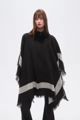 Poncho de tejido grueso, color negro y gris, con diseño de franjas diagonales y cuello alto con cierre. Presenta terminaciones con flecos.