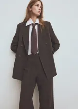 Pantalón de vestir marrón con sutil estampado a cuadros, de corte recto y tiro medio con raya central marcada.