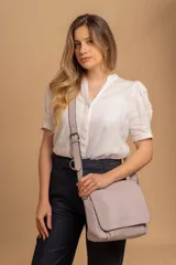 Bandolera de diseño simple con tapa frontal, confeccionada en material símil cuero. Cuenta con correa ajustable, división interna y bolsillos internos para mayor organización.