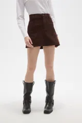 Falda mini de corte recto confeccionada en gamuza sintética color marrón, con cierre frontal de botón y presillas para cinturón.