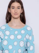 Buzo gris de tela deportiva con estampado de caritas felices rosas, manga larga y cuello redondo.