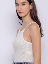 Musculosa blanca de tela texturada con tirantes finos.
