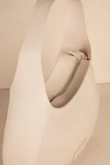 Mini bag color crema en símil cuero texturizado con asa fija.