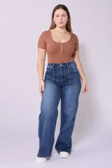 Pantalón de jean azul oscuro, corte wide leg, tiro alto y detalle de bolsillos frontales con costuras a la vista.