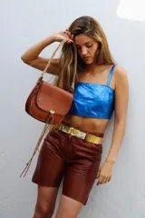 Top corto estilo corset o bandeau, color dorado metálico, con tirantes anchos ajustables.