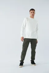 Buzo blanco de algodón con cuello redondo, mangas largas y logo y arte en relieve en el frente.