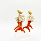 Par de aros colgantes con cabezal beige, cuentas color crudo y piezas tipo coral naranja. Se ajustan con perforación y no contienen níquel.