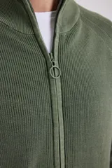 Cardigan azul de tejido de punto con cierre frontal y cuello alto.