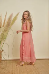 Vestido largo color salmón, con escote redondo, sin mangas y detalle de volados en un lateral.