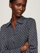 Camisa azul con estampado de rombos blancos, cuello con lazo y mangas largas.