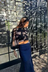 Falda larga azul de tafeta, ajustada en la cintura y con volado amplio con tajo lateral.