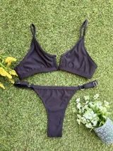 Conjunto de bikini negro texturizado, con corpiño en V y bombacha colaless regulable.