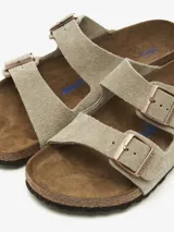 Sandalias Birkenstock Arizona SFB de cuero color topo, con plantilla anatómica de corcho y látex cubierta de ante. Ajuste con dos hebillas metálicas color cobre.