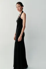 Vestido largo negro de cuello halter, espalda descubierta y escote redondo. Presenta un diseño de punto combinado en la parte superior y una falda larga de tejido fluido.