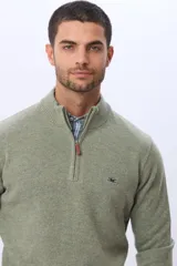 Buzo tejido de lana con cuello alto y medio cierre metálico frontal. Presenta puños y ruedo acanalados, con logo bordado en el pecho.