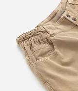 Pantalón de sarga color beige, estilo wide leg, con cintura tipo clochard ajustable con lazo.