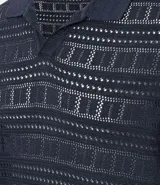 Remera tipo polo de manga corta con cuello en V, confeccionada en un tejido con textura patchwork. Presenta un diseño elegante y versátil, ideal para un look casual o formal.