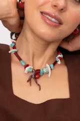 Collar corto elaborado con cuentas de turquesa reconstituida, piezas de nácar blanco, cuentas de cristal rojo y turquesa, y un dije central con forma de rama de coral.