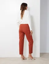 Pantalón de gabardina elastizada color fucsia, de corte recto y pretina ancha pespunteada. Tiene bolsillos simulados.