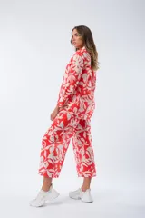 Pantalón palazzo rojo con estampado de hojas blancas, cintura elástica y corte amplio.