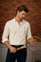 Camisa azul marino de pana, de corte slim fit, con cuello clásico, botones delanteros claros y detalle de ave bordada en el pecho.