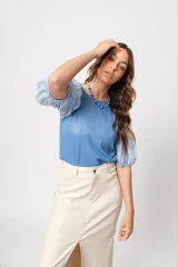 Blusa azul de cuello redondo y manga corta abullonada con puño elástico.