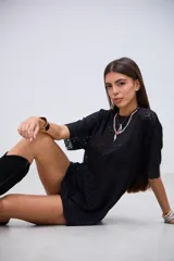 Remeron de encaje negro con diseño floral, de corte holgado y mangas cortas.