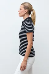 Remera de tejido canalé a rayas horizontales blancas y negras, con cuello polo y escote en V sin botones, de manga corta y corte ajustado.