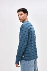 Remera de manga larga con diseño de rayas horizontales en tonos azules. Confeccionada en algodón lavado con textura suave y corte clásico.