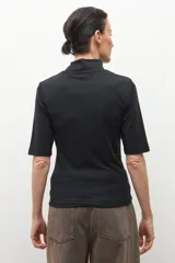 Remera de cuello alto tipo media polera, de manga corta y corte ajustado al cuerpo, en color crudo.