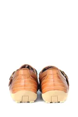 Zapato bajo de cuero negro con hebilla dorada.