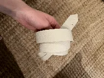 Cinturón de cuero color camel, tipo lazo simple, sin costuras ni agujeros, con punta afilada.