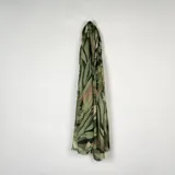 Pashmina rectangular con estampado botánico de hojas en tonos verdes y marrones, con bordes desflecados.