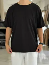 Remera oversize negra de tejido wafle, con cuello redondo y mangas cortas.