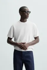 Camiseta negra de punto perlado, corte regular fit, cuello redondo, manga corta y rib en los acabados.