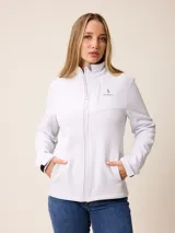 Campera softshell blanca con cierre frontal completo, cuello alto y bolsillos laterales. Presenta un bolsillo vertical con cierre en el pecho y el logo de la marca bordado.