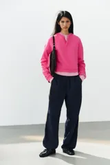 Sudadera fucsia con efecto lavado, confeccionada en mezcla de algodón. Cuenta con cuello redondo con una pequeña abertura frontal con botones, manga larga caída y puños y dobladillo en rib.