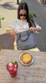 Cartera mochila de diseño versátil, color rosado, confeccionada en material sintético impermeable. Cuenta con doble asa superior, correas ajustables para usar como mochila, compartimento principal con cierre y bolsillo frontal con cierre decorado con tirador largo.