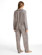 Conjunto de pijama de dos piezas con estampado animal print. La parte superior es una camisa de manga larga con cuello solapa, escote en V, cierre frontal con botones y bolsillo aplicado. El pantalón cuenta con cintura elástica y lazo de ajuste.