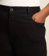 Pantalón skinny de sarga color negro, con cintura con trabillas, elástico regulador interno, cierre por cremallera y botón, y bolsillos.