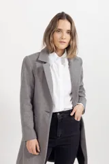 Tapado de paño color gris, con solapas clásicas, cierre frontal de un botón y corte recto a la altura de la rodilla.