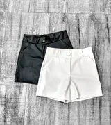 Short de cuero sintético color negro y blanco, de tiro alto y corte recto.