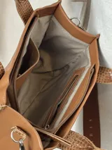 Cartera bandolera de cuero marrón con correa de tela estampada con la frase "Soy real, no perfecta".