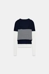 Camiseta de manga larga con diseño de efecto triple, combinando una capa superior de color azul marino, una capa intermedia de tirantes con estampado de rayas horizontales y una capa inferior blanca. Confeccionada en algodón con cuello redondo.