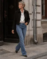 Jean Oxford de tiro alto y lavado azul medio, con diseño de cinco bolsillos y pierna que se ensancha progresivamente desde la rodilla.