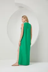 Vestido largo verde sin mangas con botones decorativos en el lateral y tajo en la pierna.